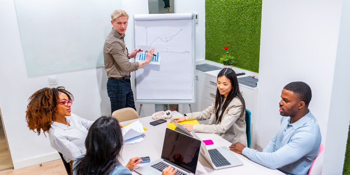 A diverse team of colleagues collaborating around a laptop in a Singapore workplace